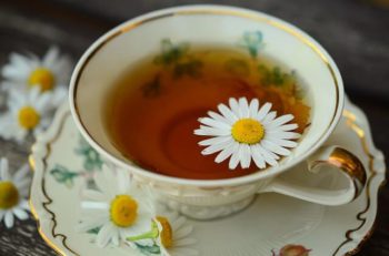 Porcelain tea cup filled with chamomile tea.